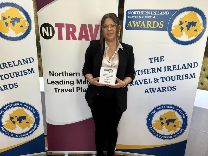 female student holds certificate at NI Travel and Tourism awards.