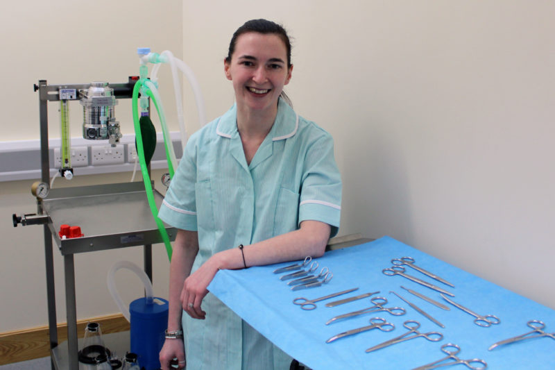 Student Emily pictured in Veterinary Surgery with tools such as scissors on a table in front of her.
