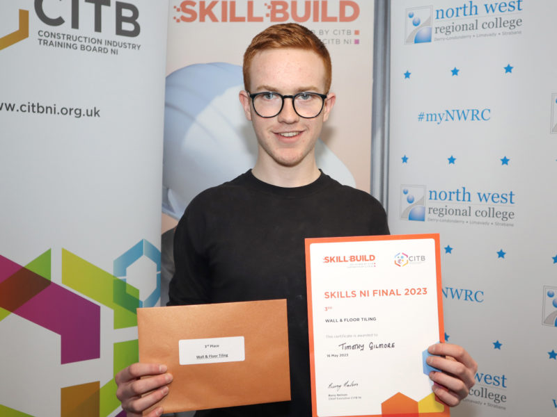 Timothy Gilmore holds a certificate for third place