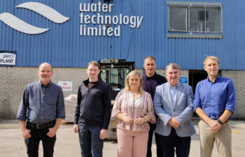 Six people standing outside a building with the branding Water Technology Ltd.