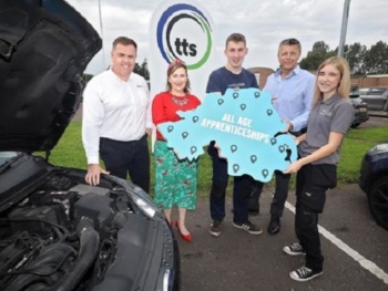 A group standing beside a car holding photo prop in the shape of a map of Northern Ireland