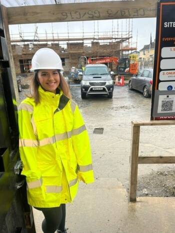 woman wearing high vis and hat on construction site