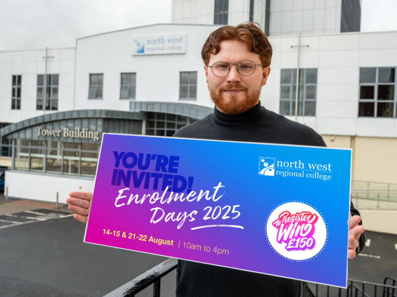 Man holding a colourful graphic promoting Enrolment days standing at the top of steps outside a college.